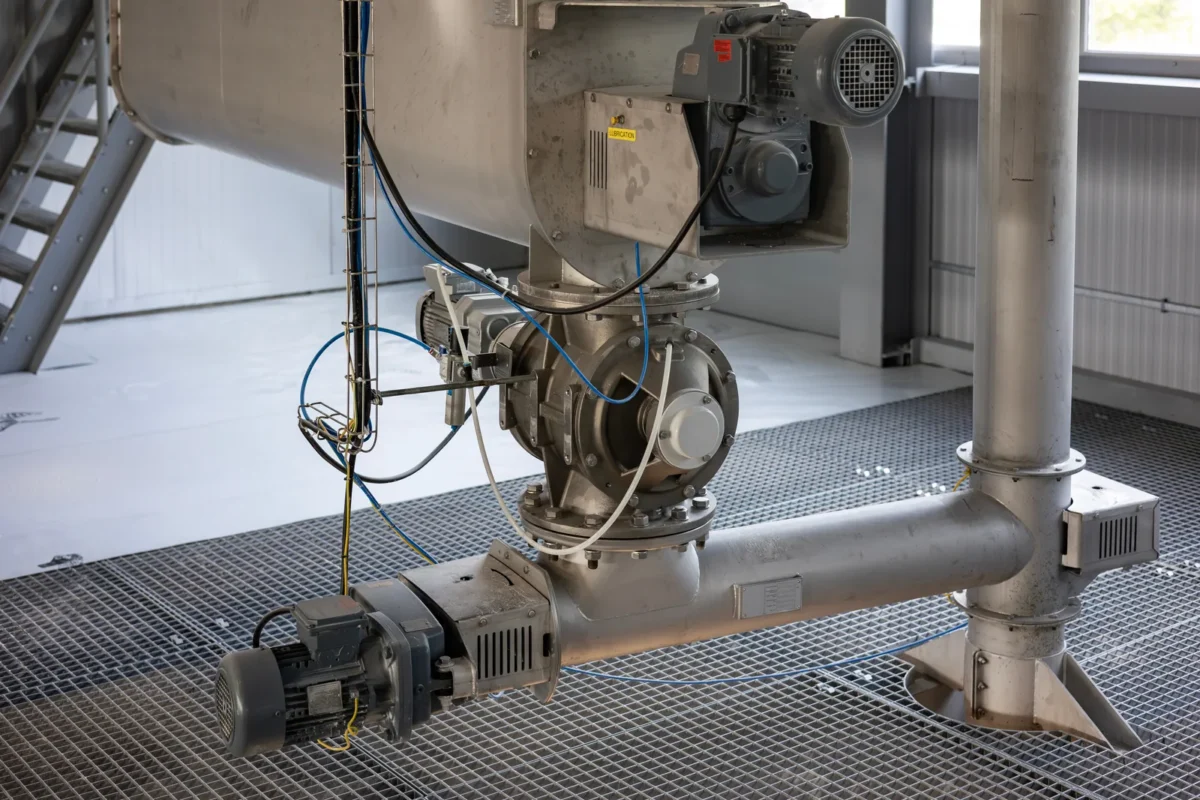 Screw conveyor and outlet equipment beneath a bulk-powder hopper.
